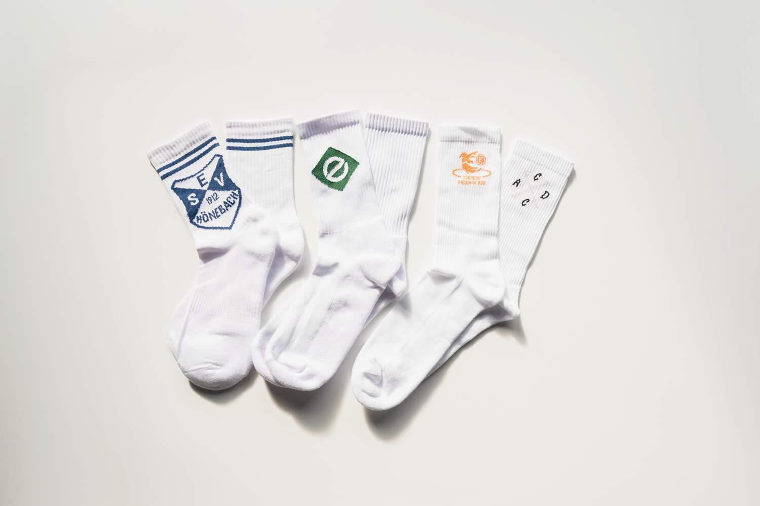 Vier individuell gewebte Socken mit verschiedenen Logos